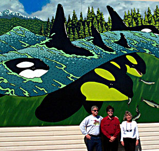 Kelley Balcomb-Bartok, whale naturalist and artist flanked by my husband and myself under Kelly's killer whale mural