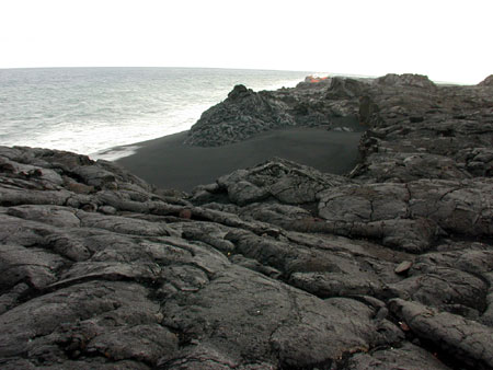 Lava flowing into the ocean and a new black sand beach