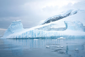 Vertical melt lines may form while the iceberg is underwater as bubbles are released while the ice melts.  The bubbles rise up to the surface and create the vertical lines in the ice.  As the berg melts from below, it becomes unstable, turns over and the underwater area becomes visible.